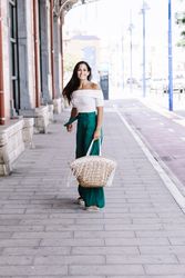 Young happy trendy woman walking in city against blue door