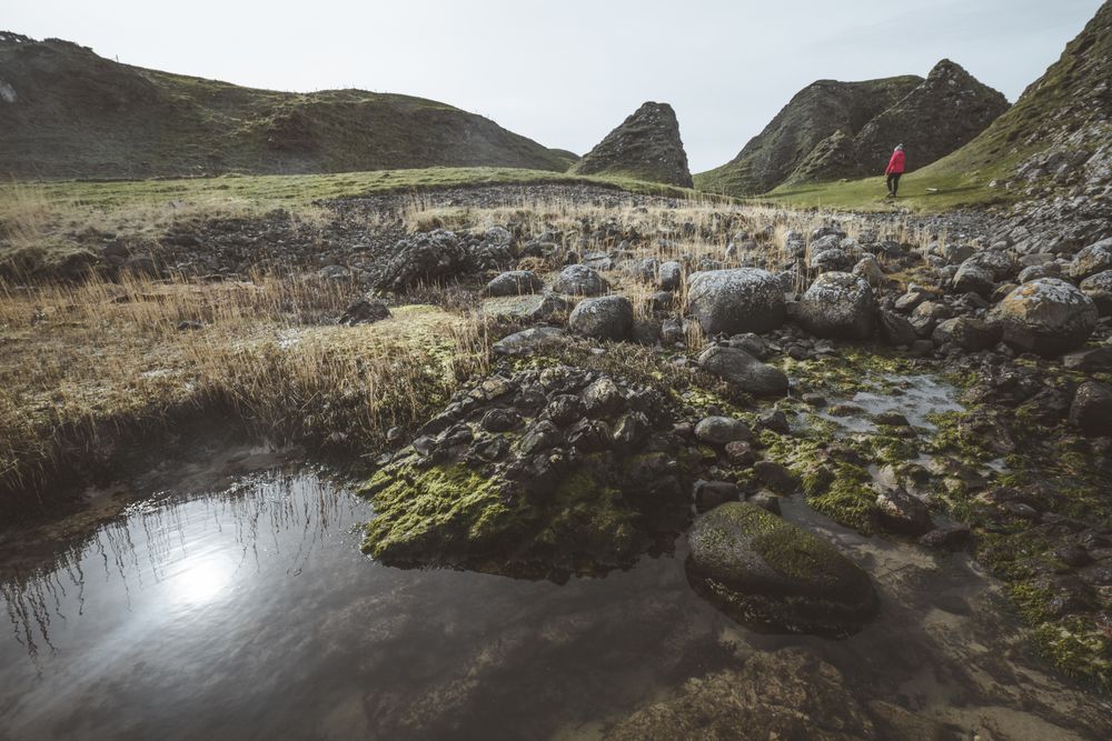 Woman walking along mountain river estuary
