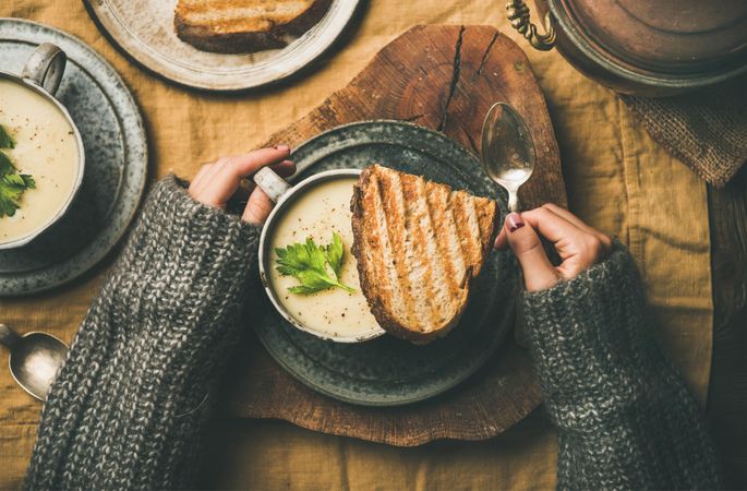 Woman with toast, and celery soup in cup