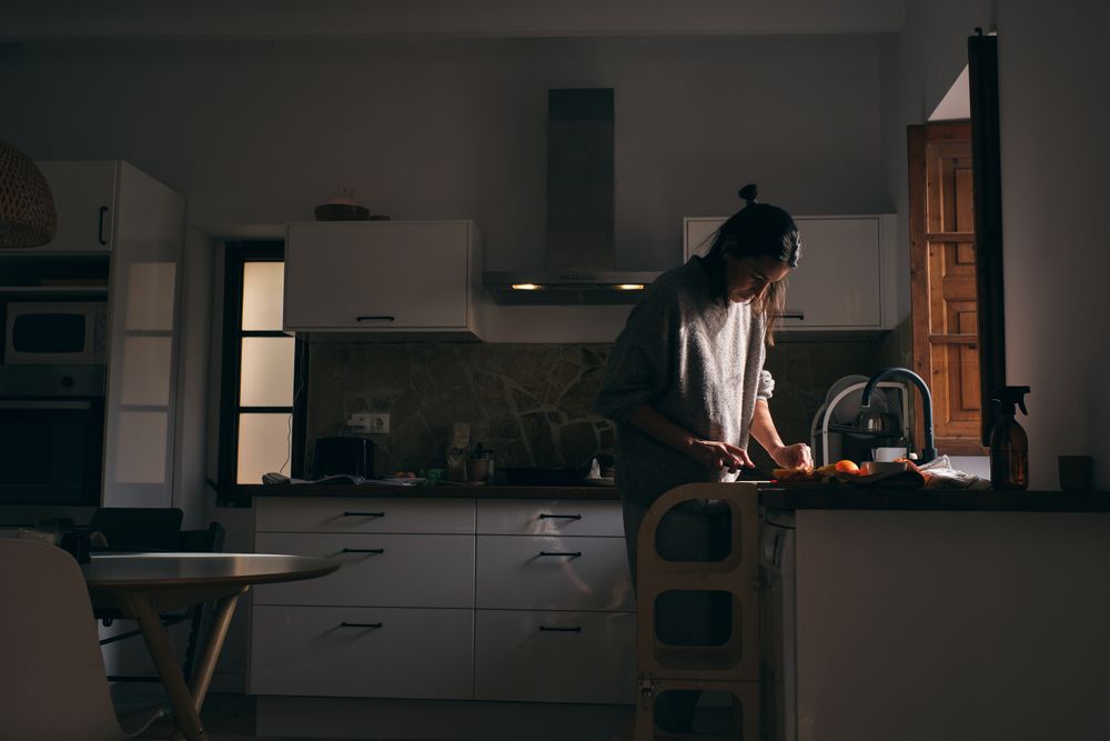 Woman cutting fruits while cooking in kitchen