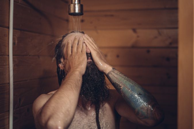 Man taking shower in wooden bathroom