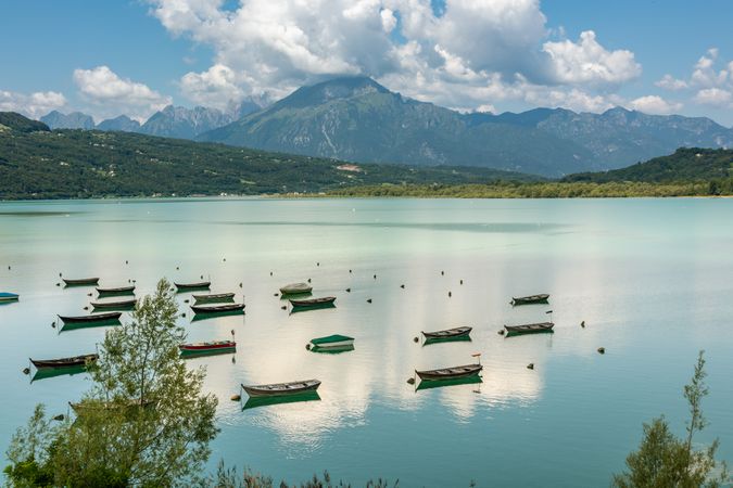 Boats on water near mountain under blue sky in Italy
