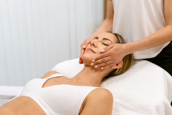 Woman having her face massaged by massage therapist