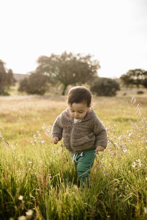 Young boy marching through a field of grass
