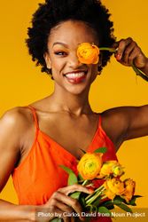 Beautiful Black woman playing with ranunculus flowers 0LnRD4