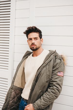 Cheerful stylish male standing against wooden wall