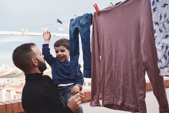 Father and son hanging clothes on rope