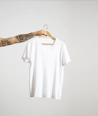 Arm holding a light t-shirt on hanger