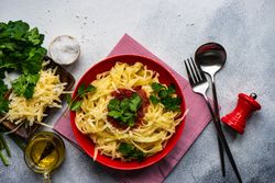 Fettuccine pasta with cheese & tomato sauce on counter with copy space