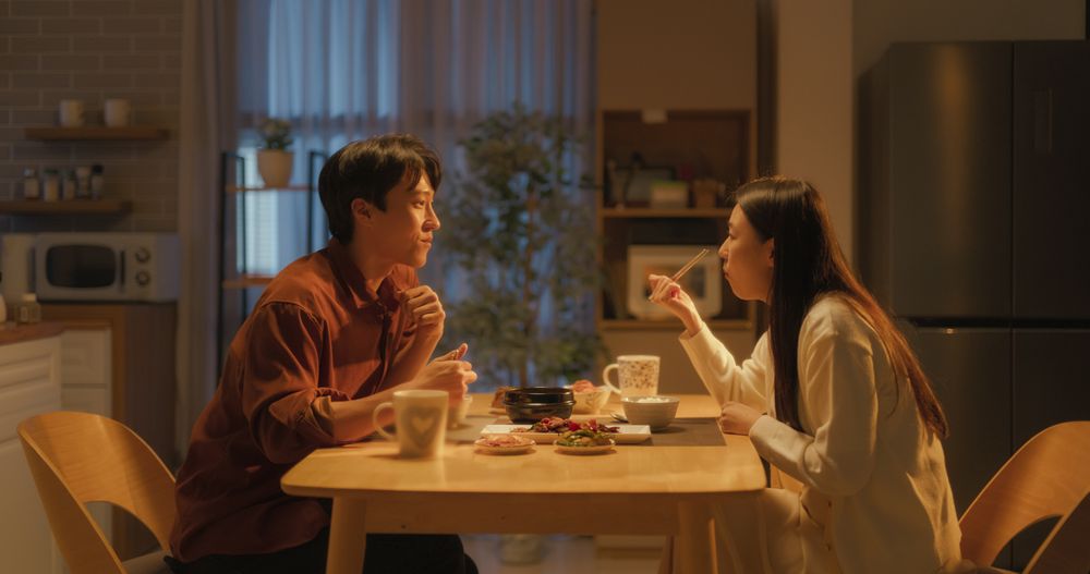 Asian Boyfriend and Girlfriend Enjoying Time Together, Feasting on Cooked Meat, Spicy Vegetable Soup and Rice
