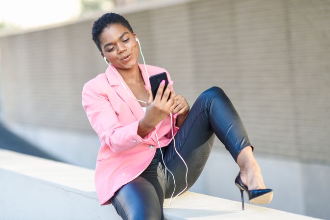 Female wearing suit with pink jacket talking on video call