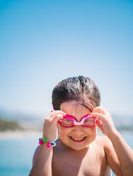 Cheerful girl in goggles after swimming in sea