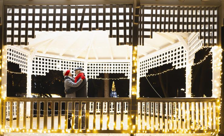 Cute mature couple embracing in a gazebo during winter