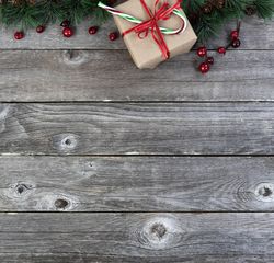Giftbox present with fir branched on old wooden boards