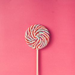 Swirling lollipop against pink background