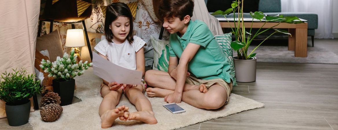 Boy and girl playing in a diy tent at home