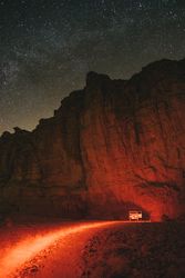 Car near cliff in evening in desert