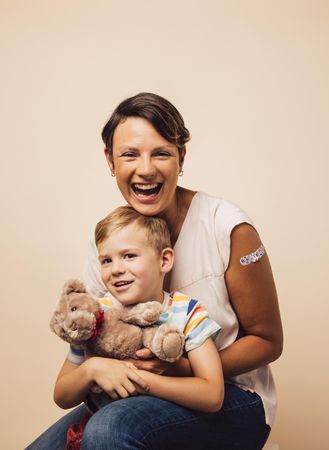 Woman holding her son with a teddy bear