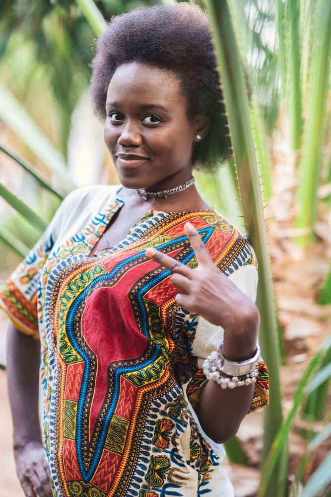 Optimistic Black female showing V sign