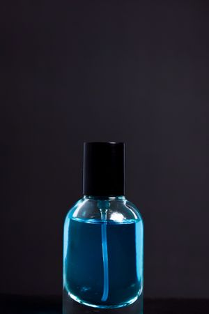 Light blue perfume bottle in studio with copy space