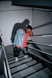 Stylish Black man leaning on metal railing