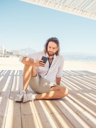 Man using smartphone on beach