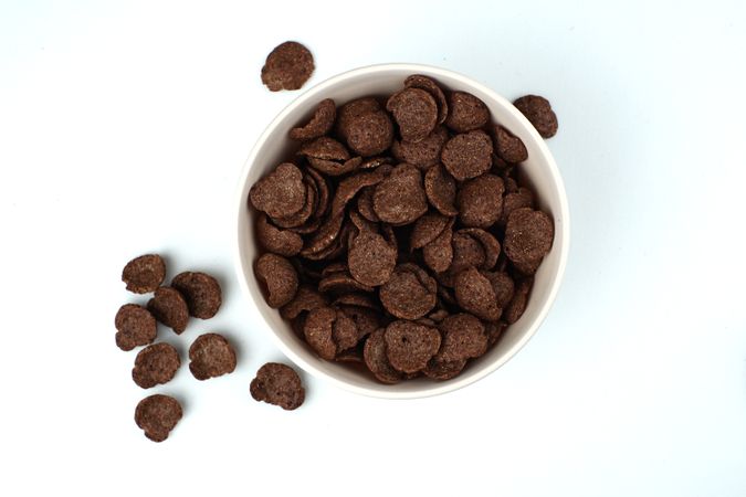 A bowl of chocolate flakes on a plain background