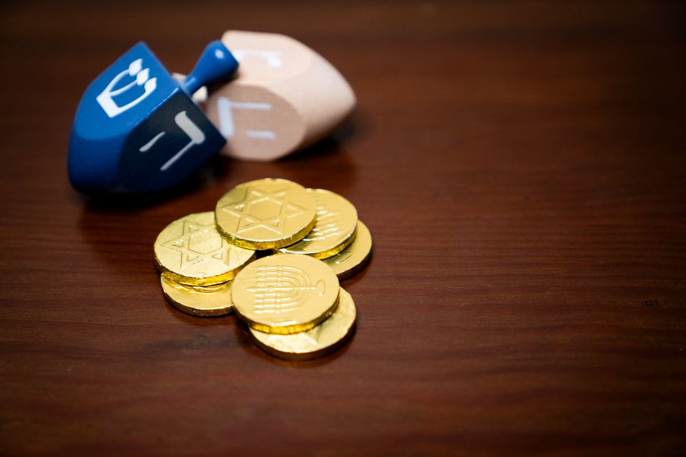Pile of golden gelt and two dreidels for Hanukkah game