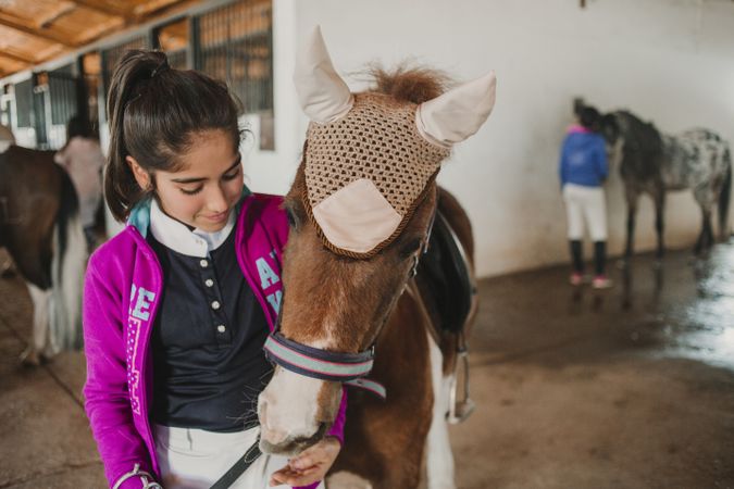 Girl with adorable pony in hat