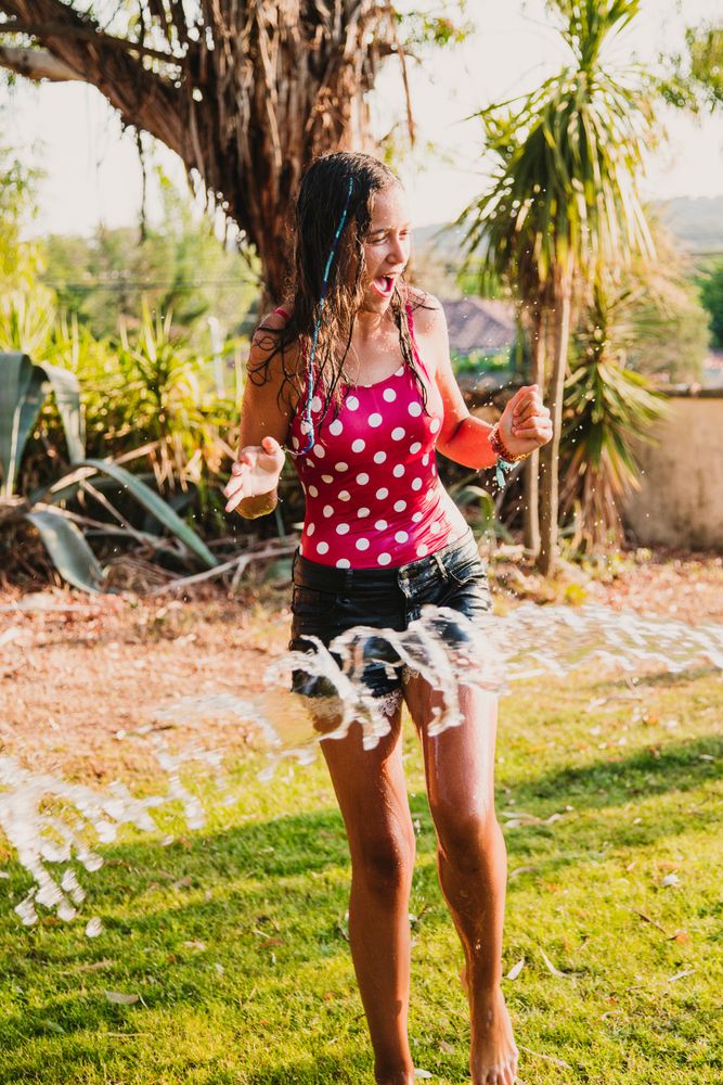 Cheerful teenager having fun with jet of water