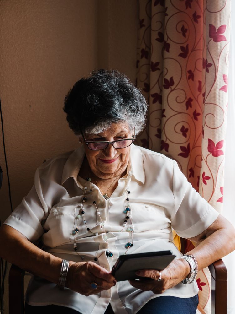 Older female reading e-book at home