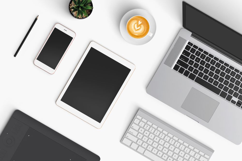Modern workspace with coffee cup, smartphone, paper, notebook, tablet and laptop