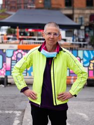 Older woman with hands on hips in neon wind breaker