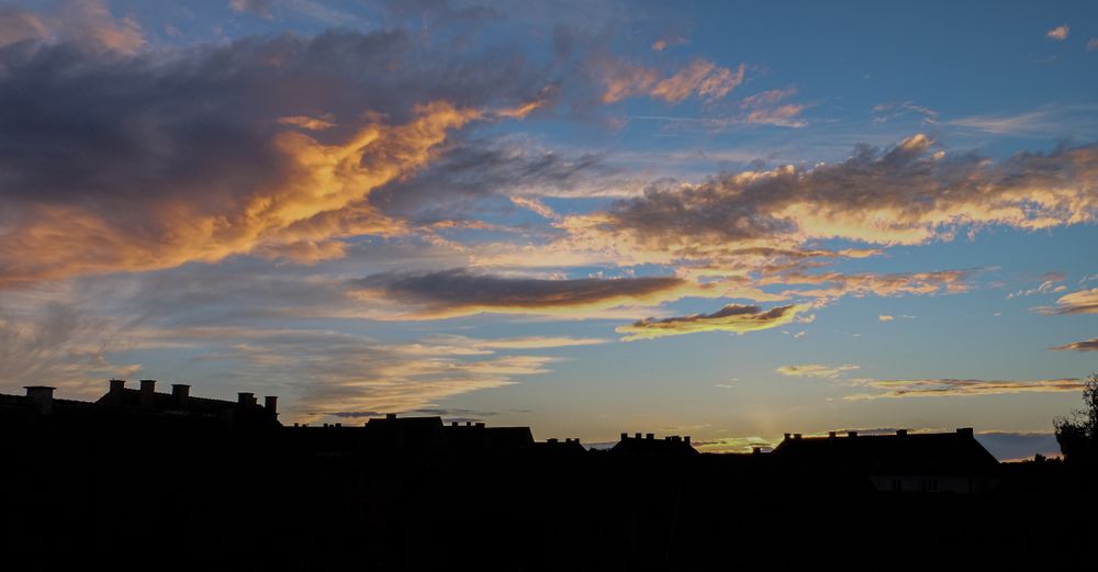 Blue sky with colorful clouds over houses