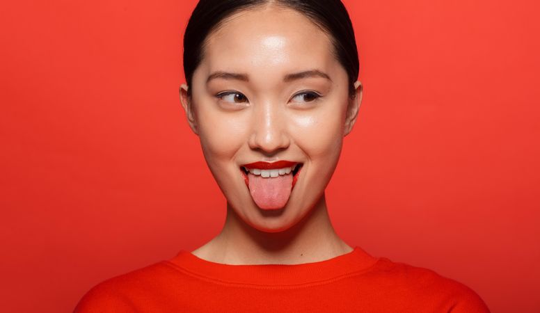 Korean female model making funny face against red background