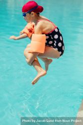 Young girl jumping into a swimming pool 5pqjv4