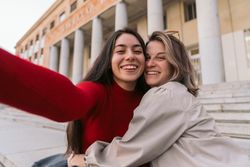 Selfie of two students smiling sitting on the stairs