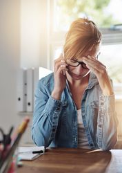 Tense woman in jean jacket taking challenging call