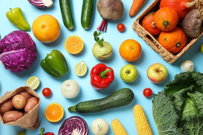 Different vegetables and fruits on blue background, top view