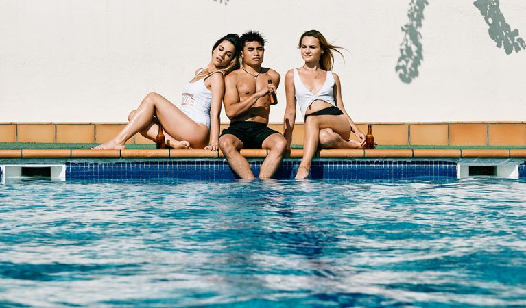 a group of young models by the pool in a summer day