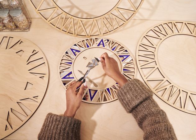 Woman cutting out pieces for a circular wooden frame