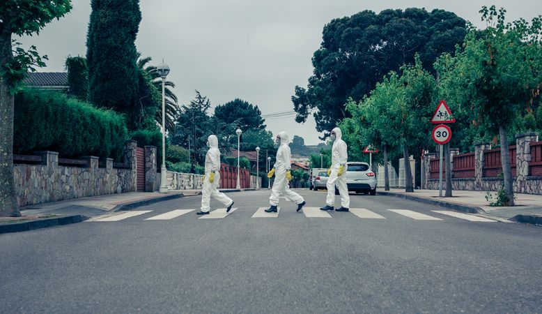 People in bacteriological protection suits walking down an empty street