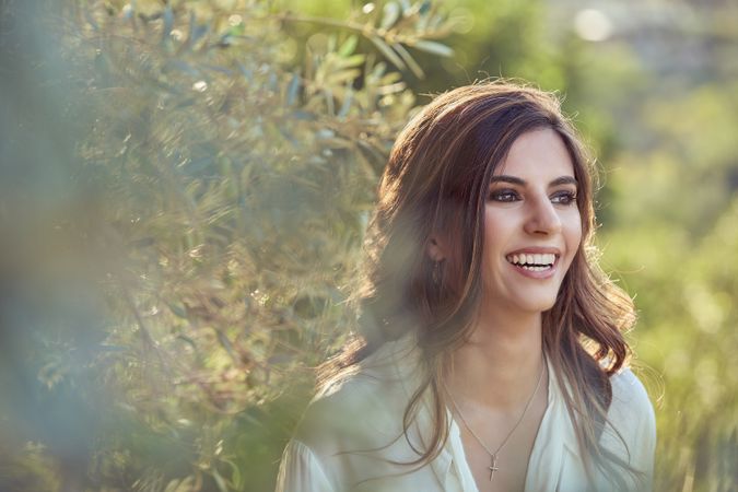 Delighted woman near green plants