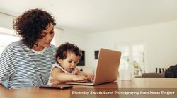 Mother holding her baby while she explores laptop computer 4dGqd5