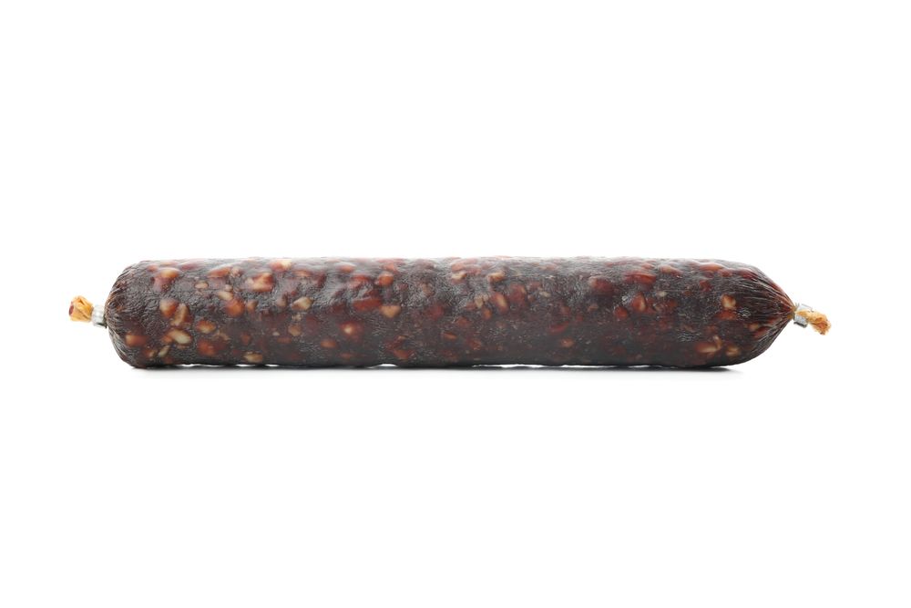 Dark cured meat stick in blank room