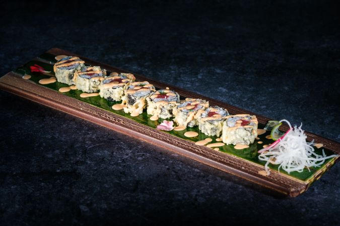 Tasty sushi rolls served on tray on marble surface