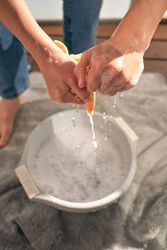 Crop person wringing out rag