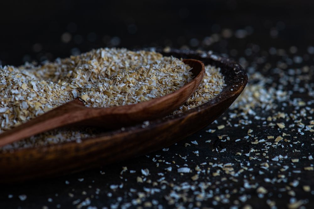 Side view of bowl of oats with wooden spoon