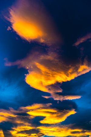 Orange clouds in blue sky background at dusk