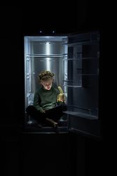 Boy eating banana and watching movie on tablet while sitting in